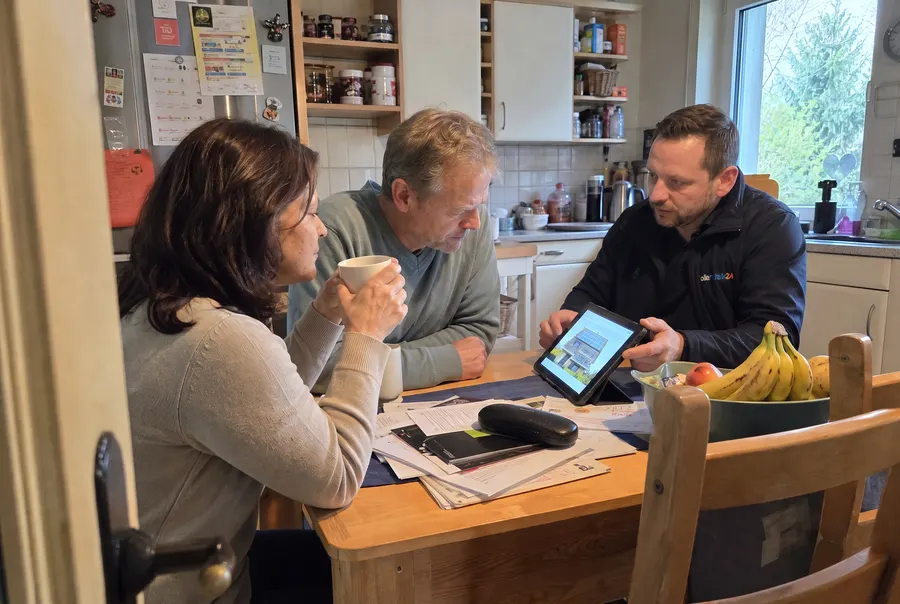 Solarcheck24-Berater zeigt einem Ehepaar die 3D-Dachplanung auf dem Tablet