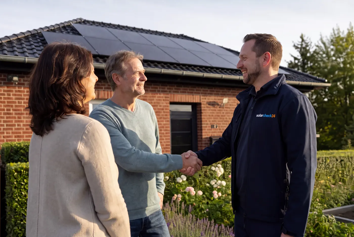Übergabe einer fertigen Solaranlage an ein zufriedenes Kundenpaar